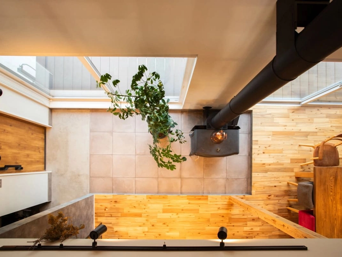 吹き抜け二階から見下ろした一階の土間とストーブ