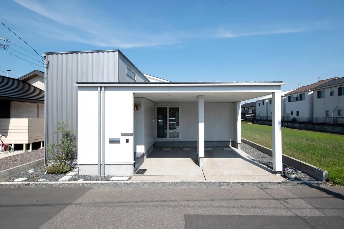 白い外壁とビルトインガレージを備えたスタイリッシュな外観