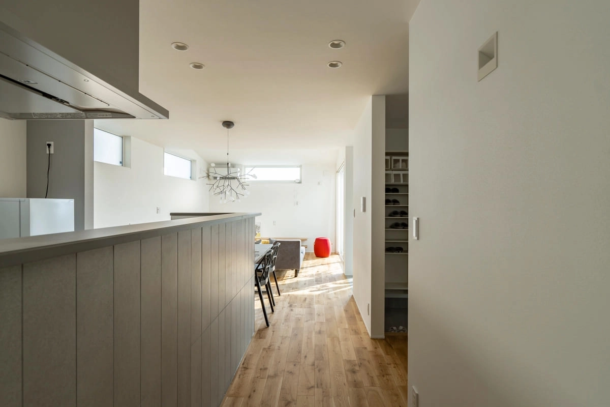 キッチンカウンターから明るいリビングへと続く奥行きある室内