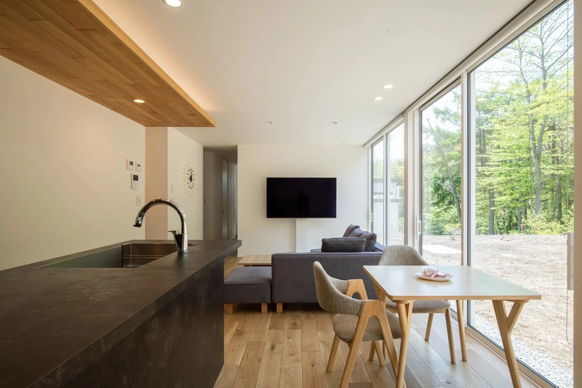 大きな窓から緑が見える開放的なLDKとキッチン