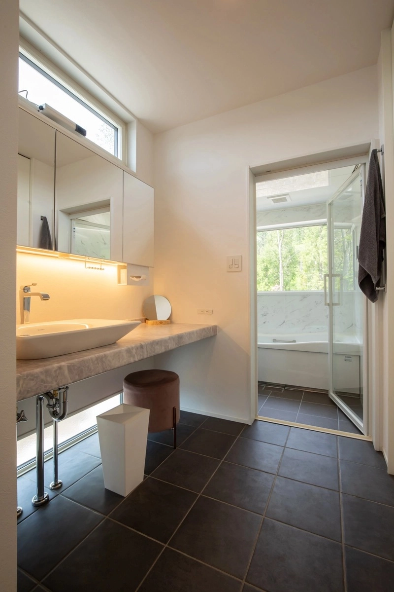 間接照明が美しい洗面コーナーと清潔感のあるバスルーム