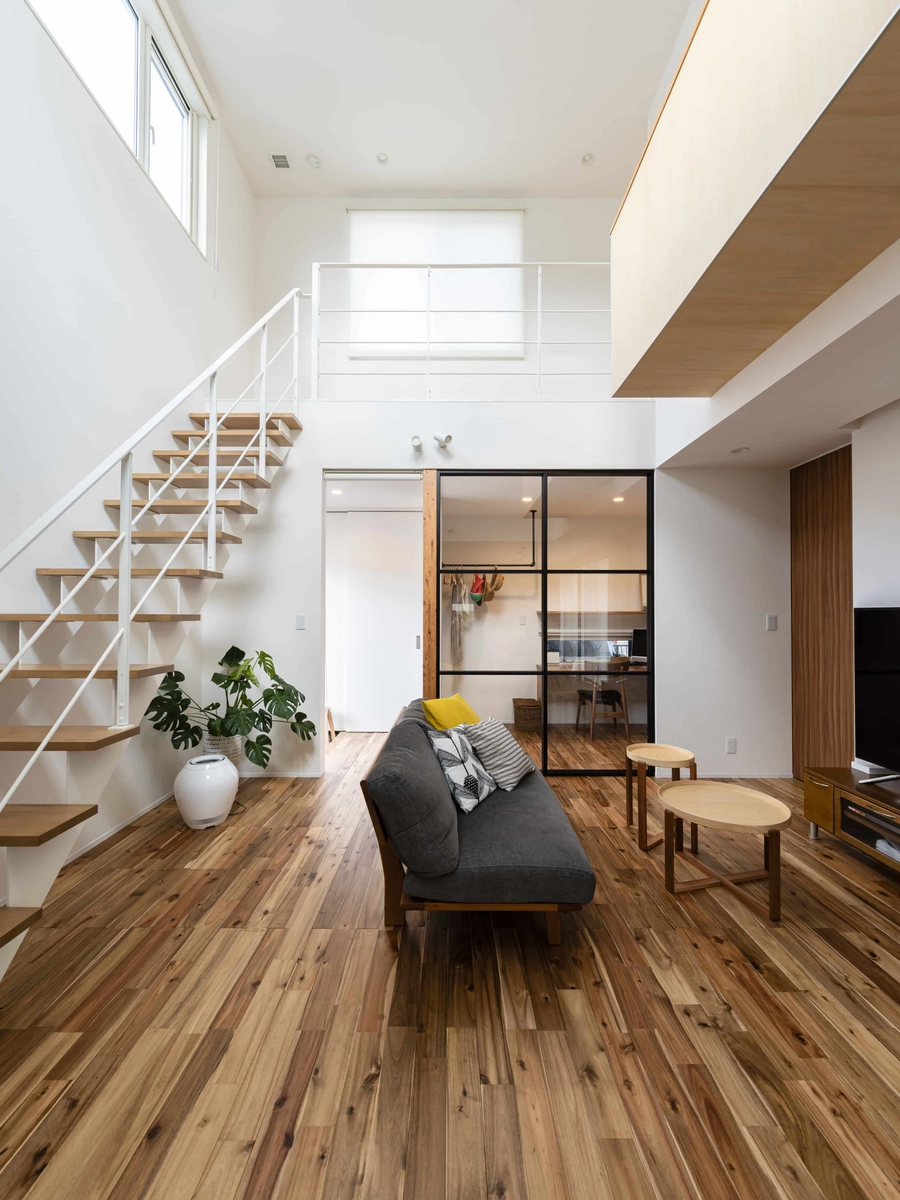 白い壁と木目フローリングの吹き抜けリビング