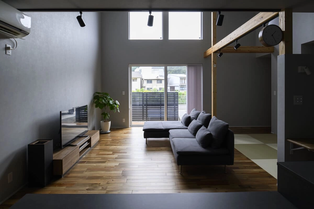 グレーの壁と見せ梁が特徴的な吹き抜けリビング
