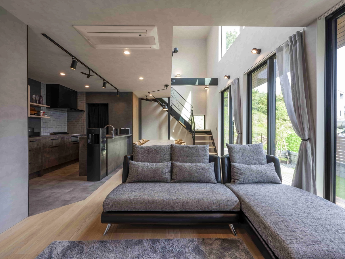 グレーのソファーがある大きな窓に面したリビング