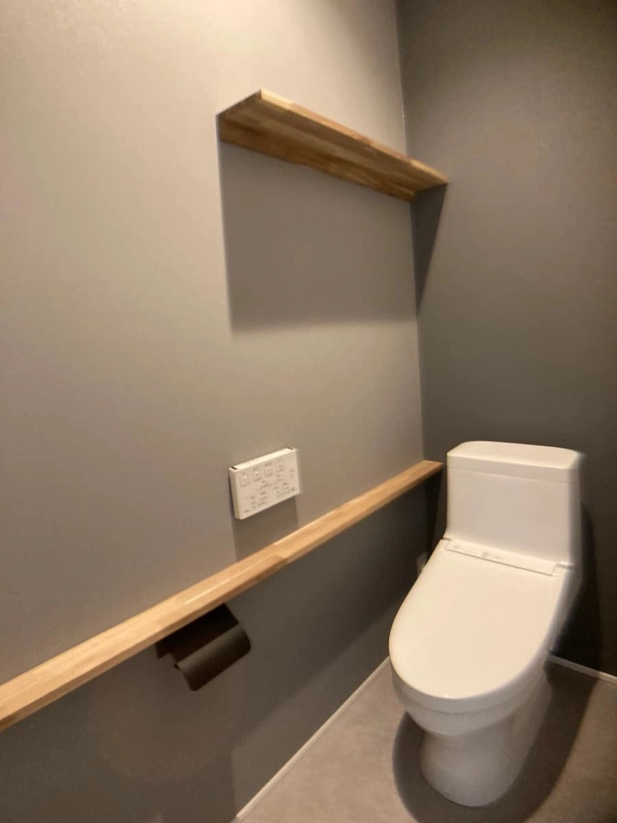 2色のグレーのクロスでまとめたシックな雰囲気のトイレ