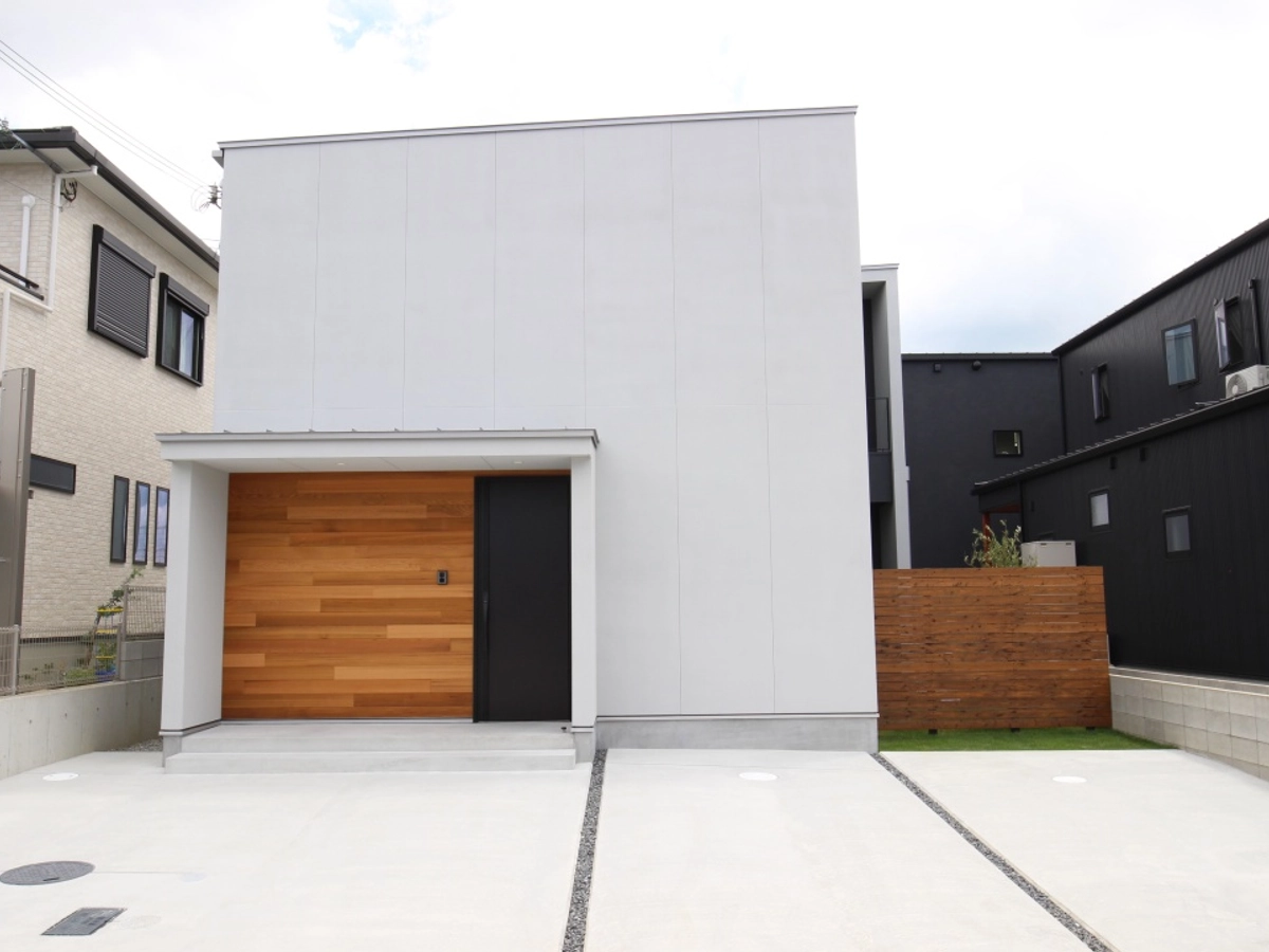 白と黒の外壁に木目がアクセントになっている外観