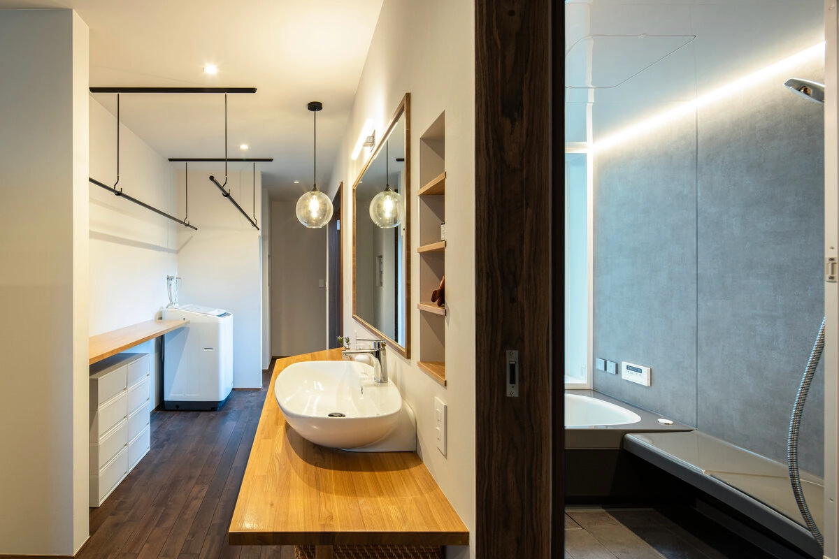 造作洗面台と室内干しスペースがある洗面脱衣室と隣接する浴室