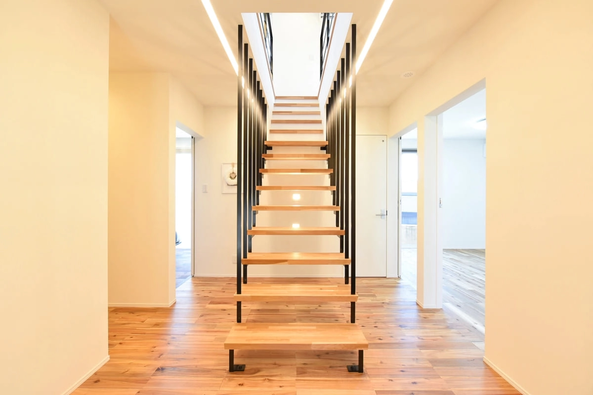 正面から見る木製段板と黒い鉄骨手すりの階段