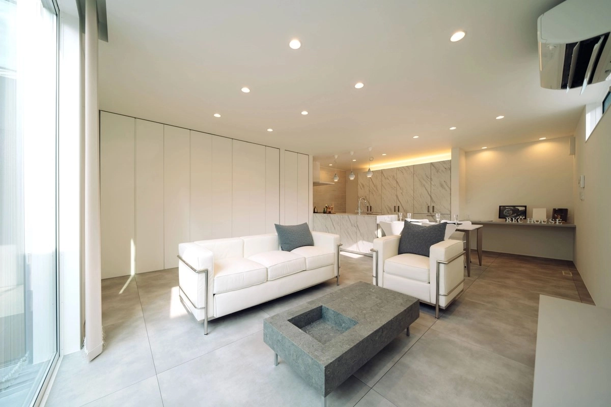 白を基調とした大理石調のキッチンと高級感のある広々としたリビング