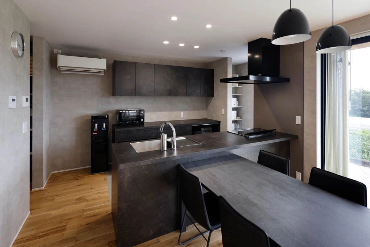 冷蔵庫をパントリーに収め生活感を減らしたモノトーン基調のキッチン