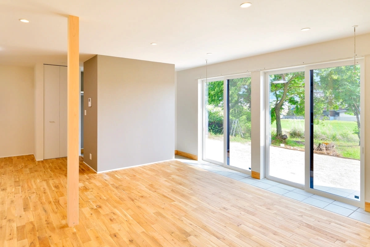 掃き出し窓から光が差し込む明るい無垢床のリビング