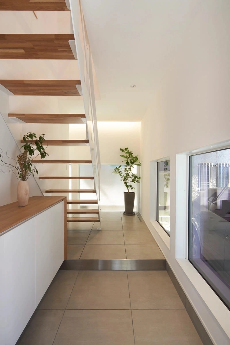 窓越しにビルトインガレージの愛車を眺められる玄関ホール