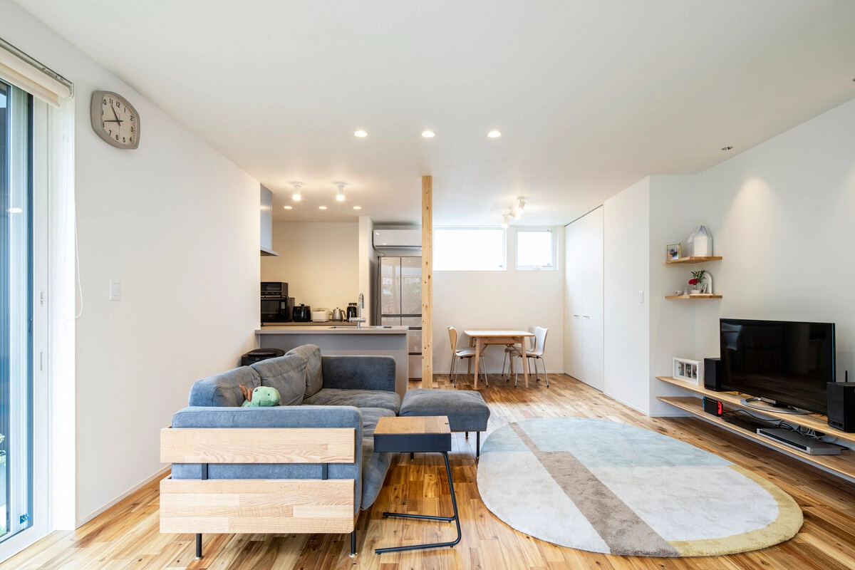 木目調の床とグレーのソファがある明るいLDK