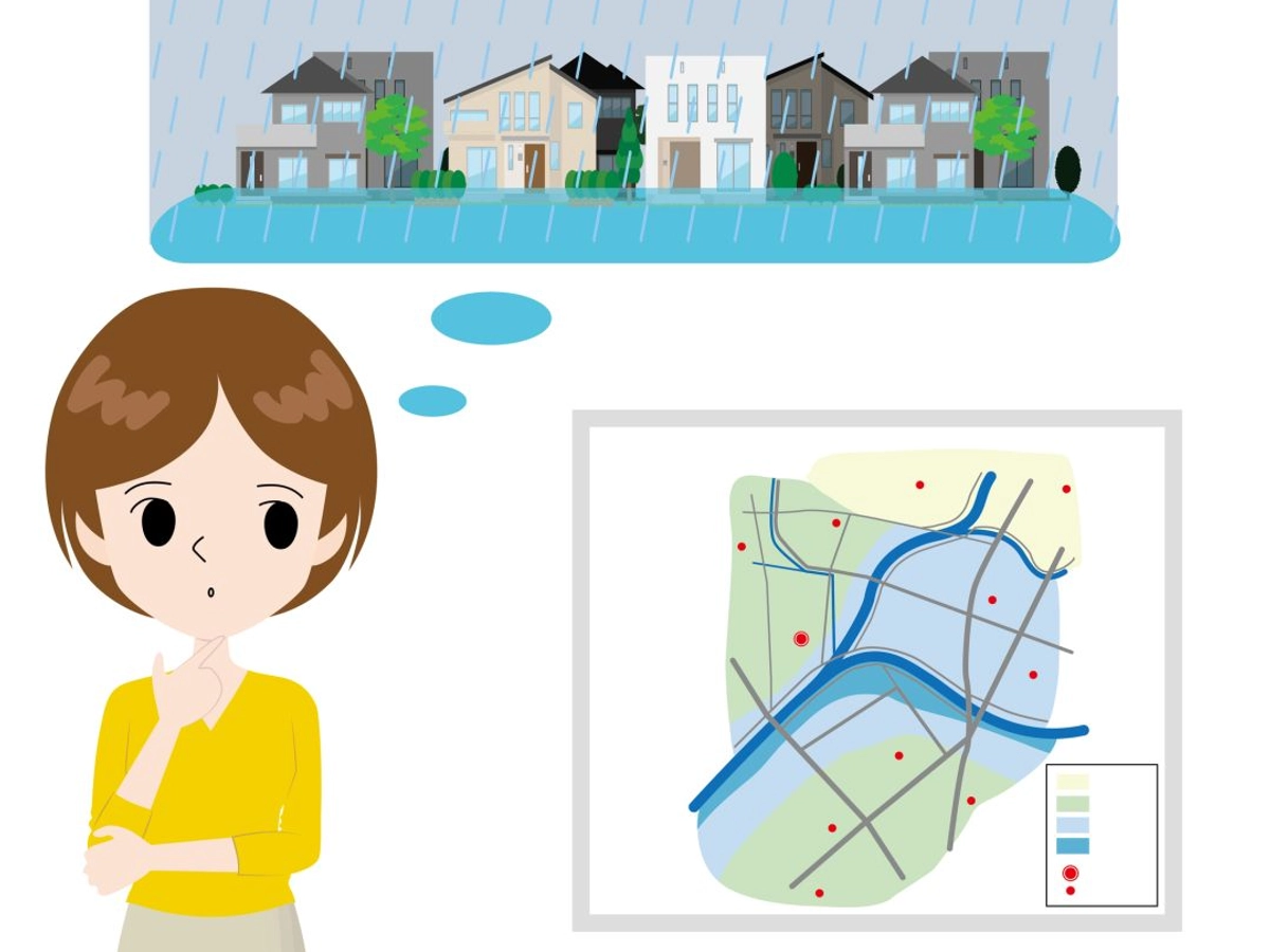 ハザードマップと街が浸水した場面を想像する女性