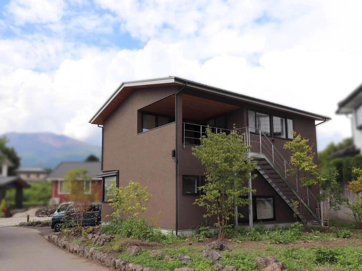 バルコニーと庭をつなぐ階段の設置されたブラウンの家