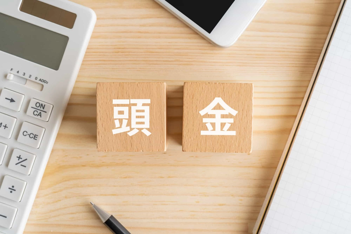頭金と書かれたブロック、電卓、スマホ、ノート、ペン
