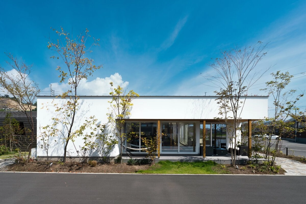 青空に映える白い外壁と深い軒があるモダンな平屋の外観