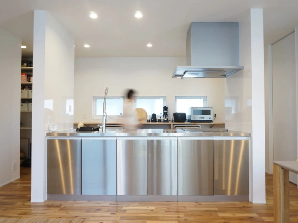 リビングから見た明るいキッチンと程よく隠れたパントリー