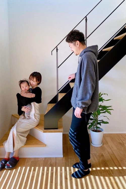 鉄骨階段と腰掛ける夫婦と赤ちゃん