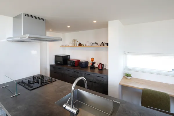 風景と重なる大きな窓の家のキッチン