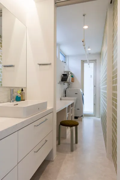 土間と繋がる中庭 白いコートハウスの家事スペース・洗面所