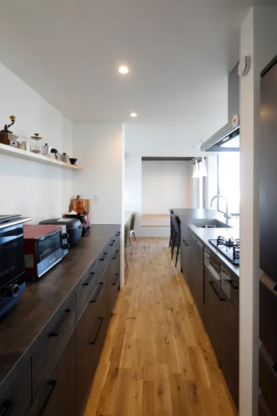 風景と重なる大きな窓の家のキッチン