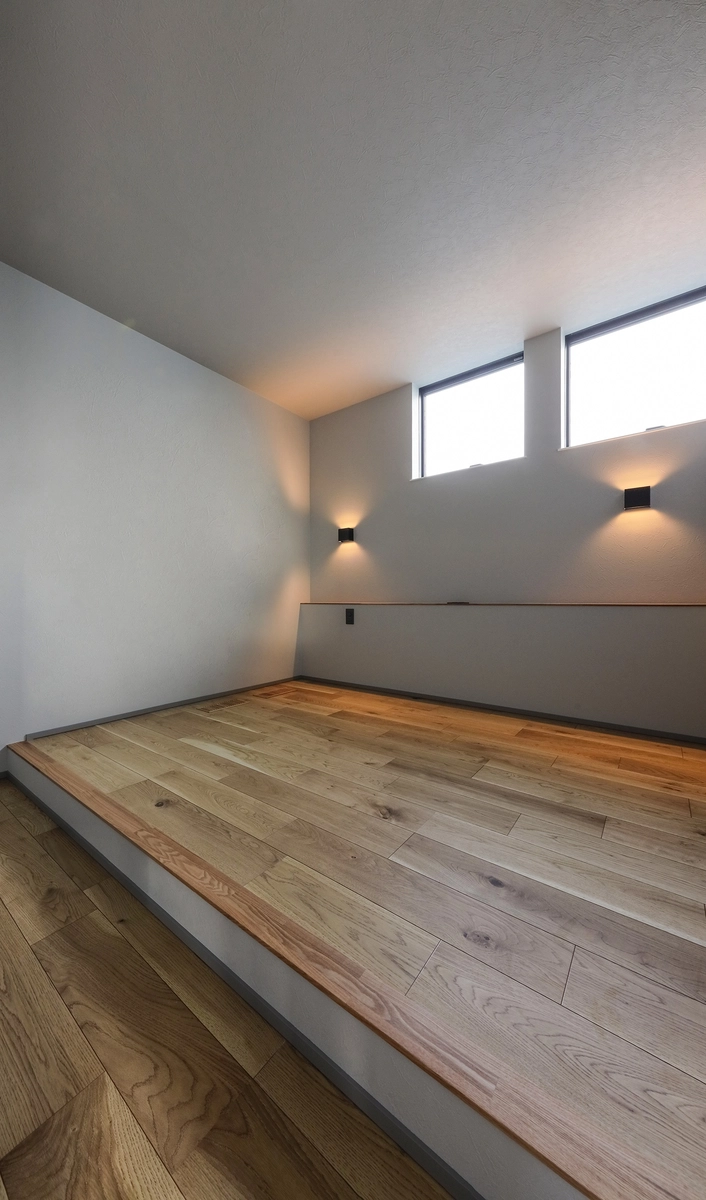 空へ抜けるグレーの家の寝室