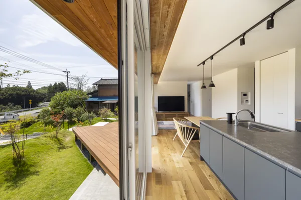 のどかな田園風景を臨む 白く美しい箱型の平屋のリビング・ダイニング・キッチン・テラス・デッキ