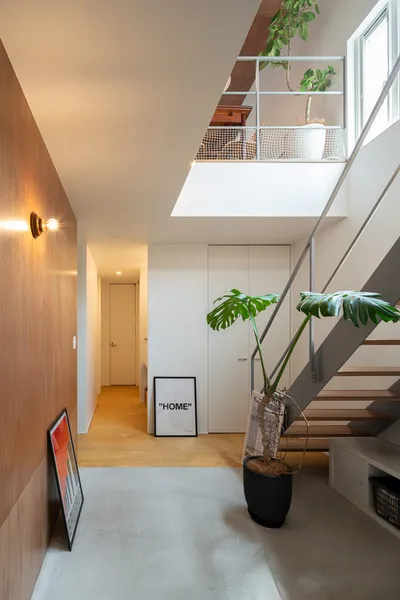 光を導くミッドセンチュリーの家の吹き抜け・階段・土間