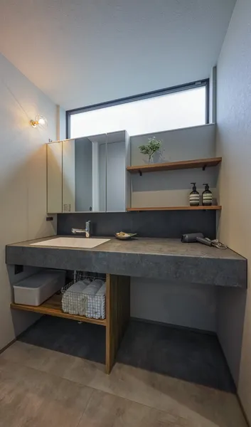 空へ抜けるグレーの家の洗面所