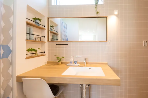 傾斜地を活かした 2つの入口を持つ家の洗面所・アクセントウォール