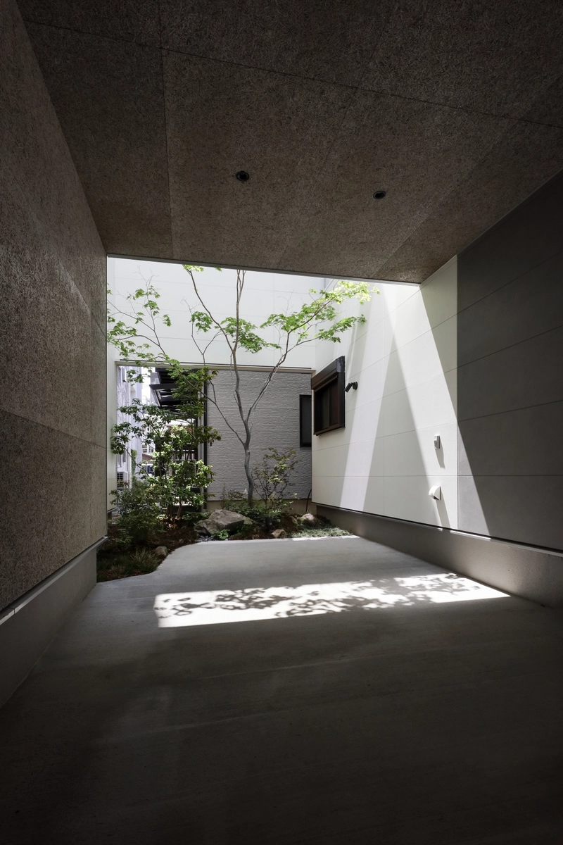 都市で自然を感じる3層の光庭住宅のガレージハウス