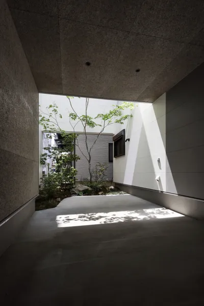 都市で自然を感じる3層の光庭住宅のガレージハウス